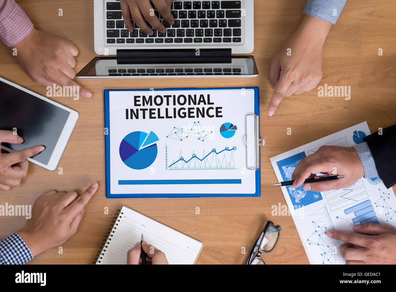 EMOTIONALE Intelligenz-Business-Team die Hände bei der Arbeit mit Finanzberichte und Laptop, Ansicht von oben Stockfoto