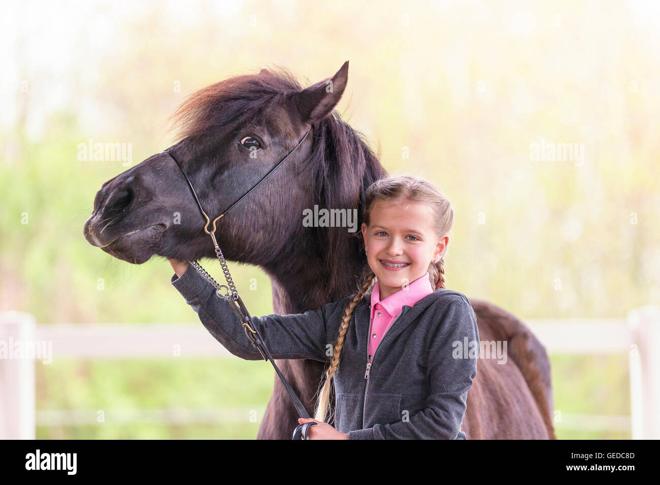 Shetland-Pony. Kind im Kleid stehen neben Bucht Erwachsenen Reiten. Deutschland Stockfoto