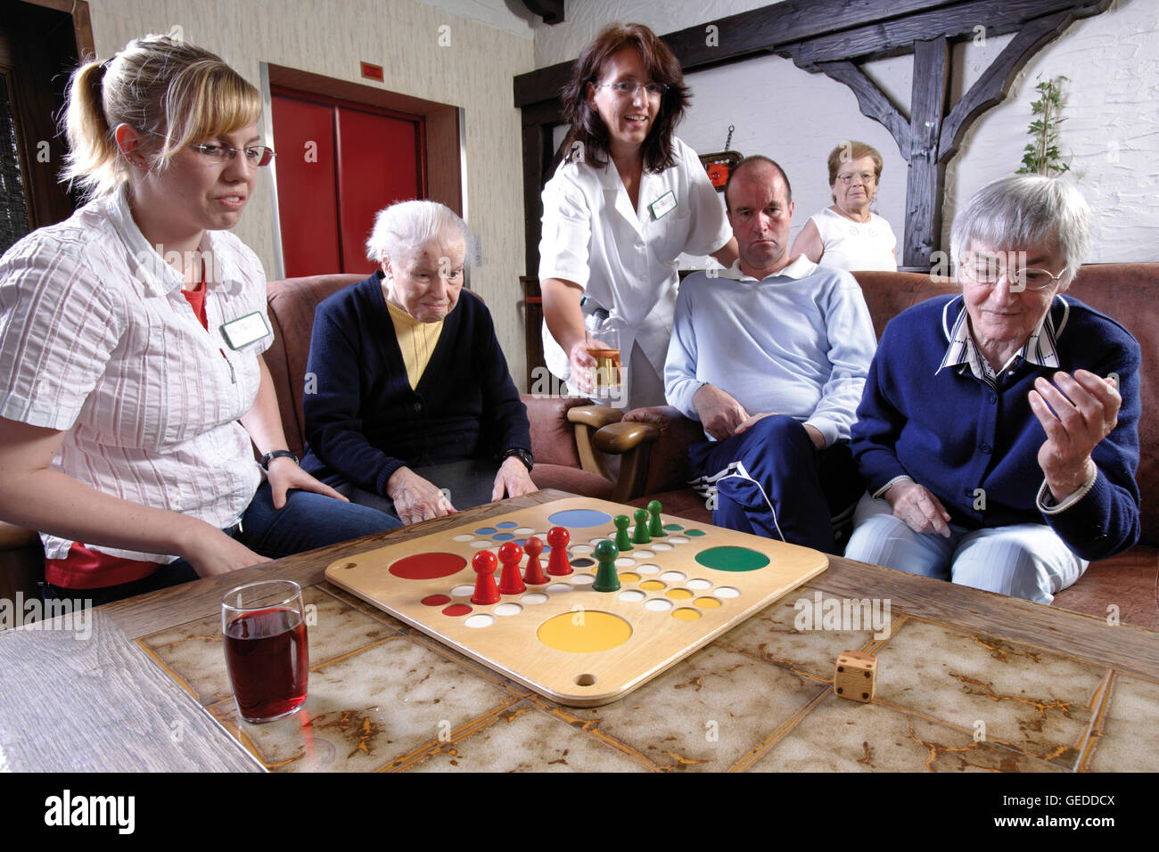 Pflegekräfte und Bewohner ein Altersheim oder Pflegeheim Brettspiele am Nachmittag Stockfoto