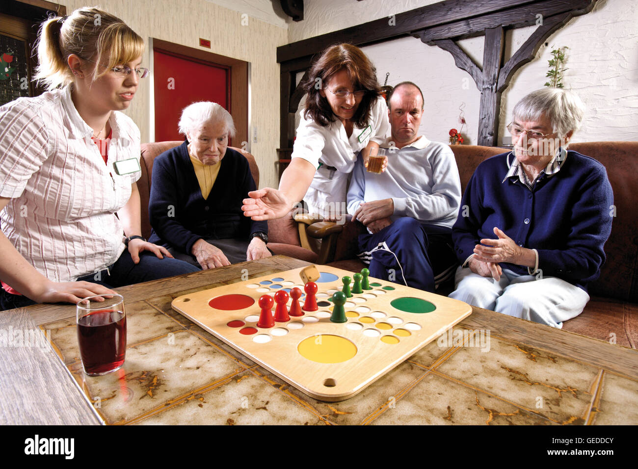 Pflegekräfte und Bewohner ein Altersheim oder Pflegeheim Brettspiele am Nachmittag Stockfoto