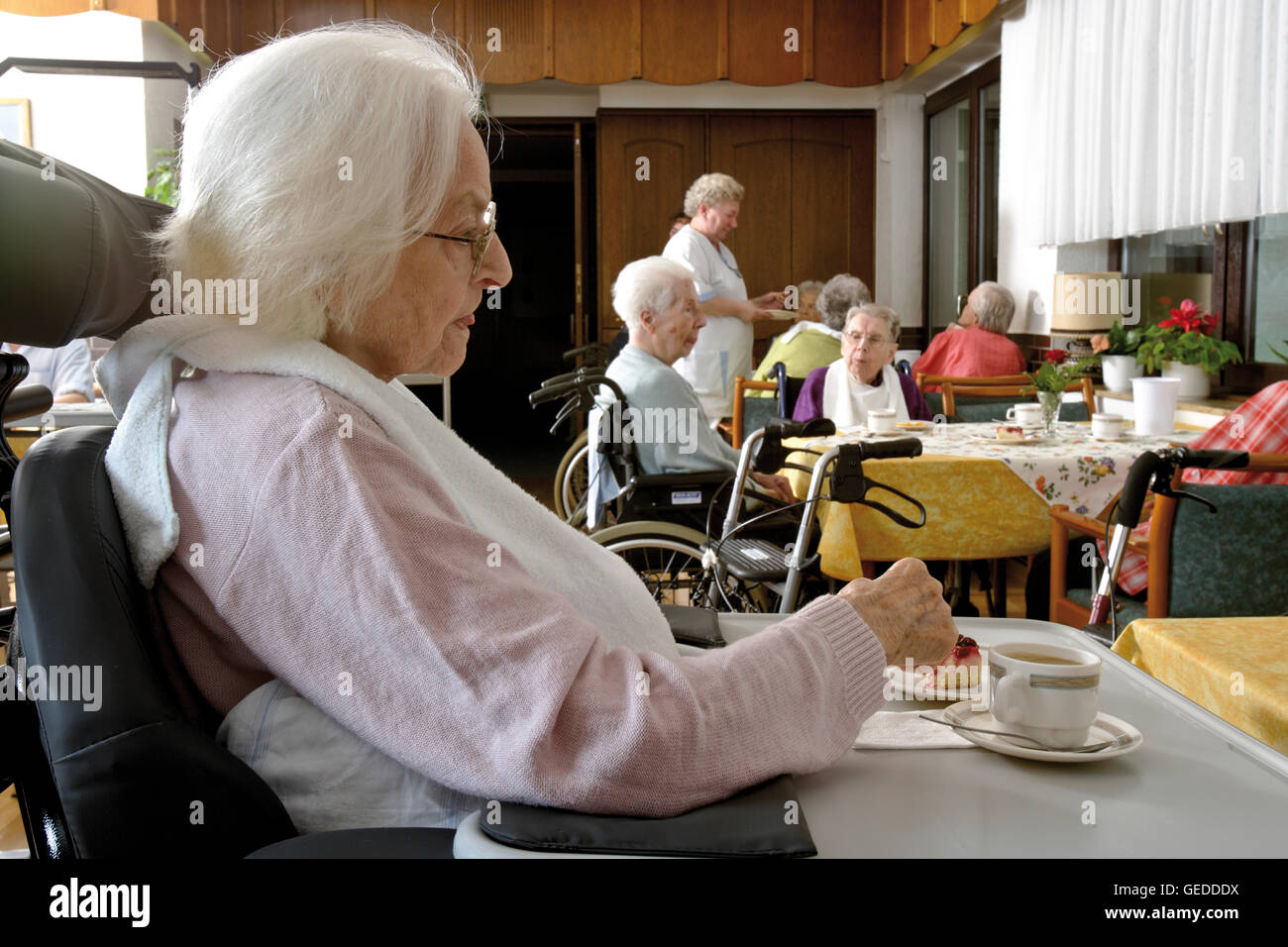 Bewohner sitzen im Speisesaal Kaffeetrinken in einem Pflegeheim Stockfoto