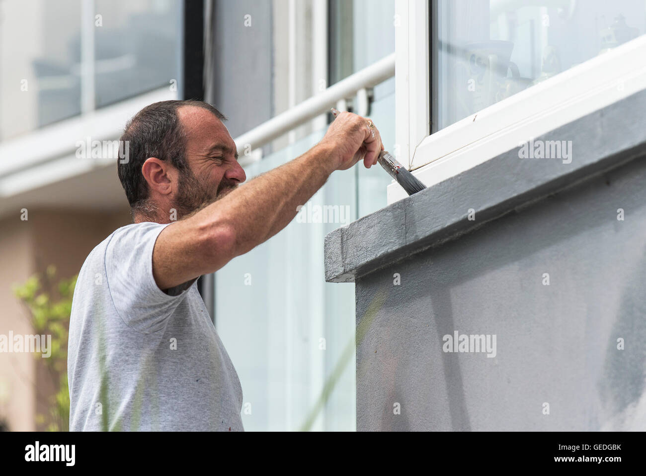 Maler und Dekorateur malt die Außenwand eines Hauses. Stockfoto