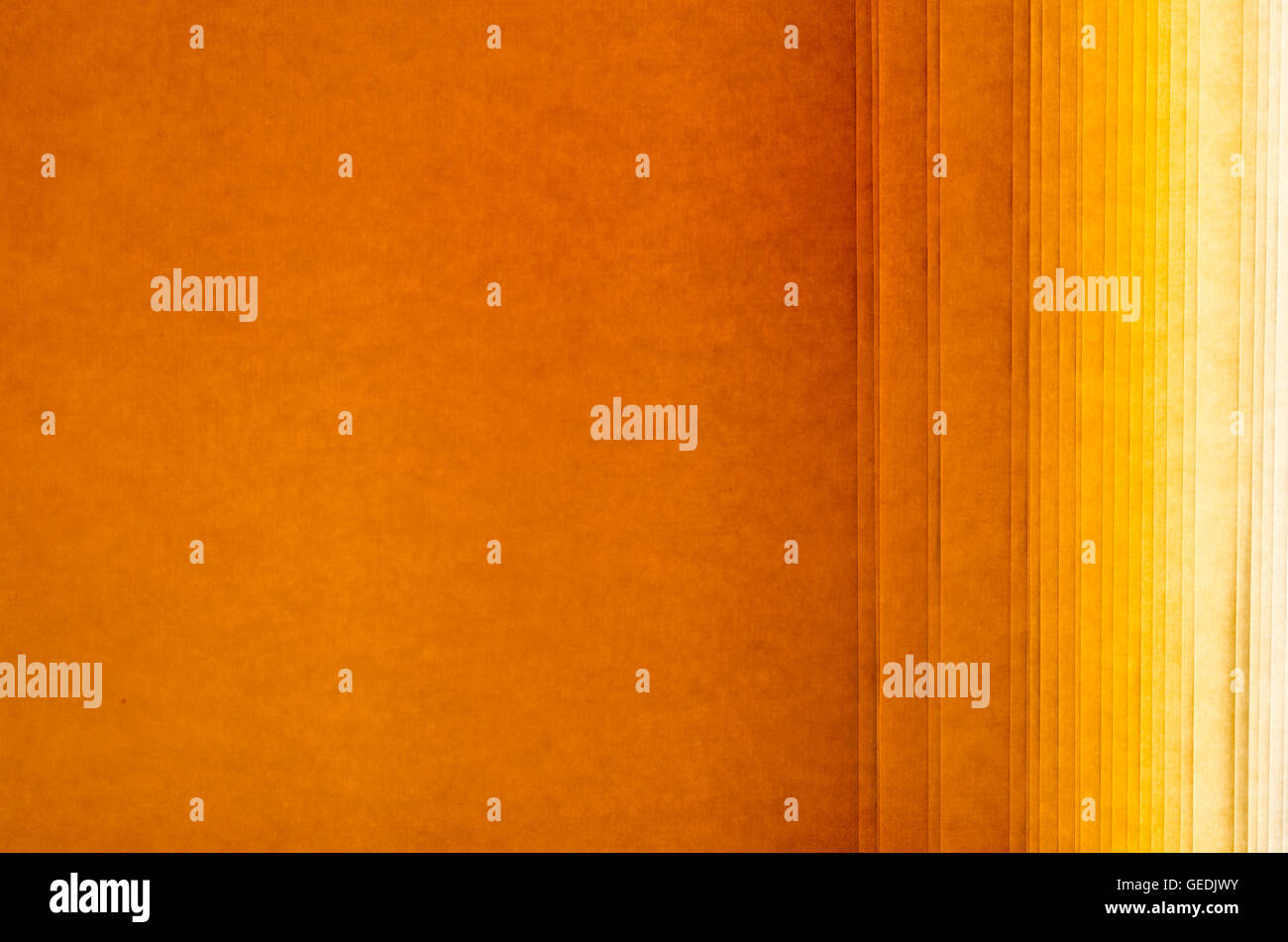 Papierrolle für grafische Verwendung texturiert mit parallelen Linien mit warmen Farbtönen von orange Stockfoto