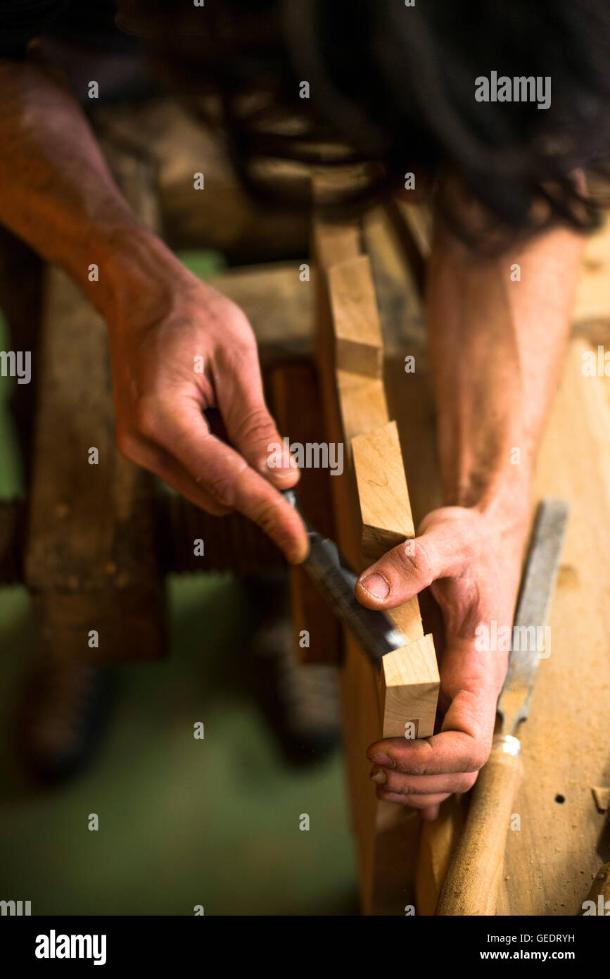 Schreiner mit Meißel auf Stück Holz, High Angle View Stockfoto