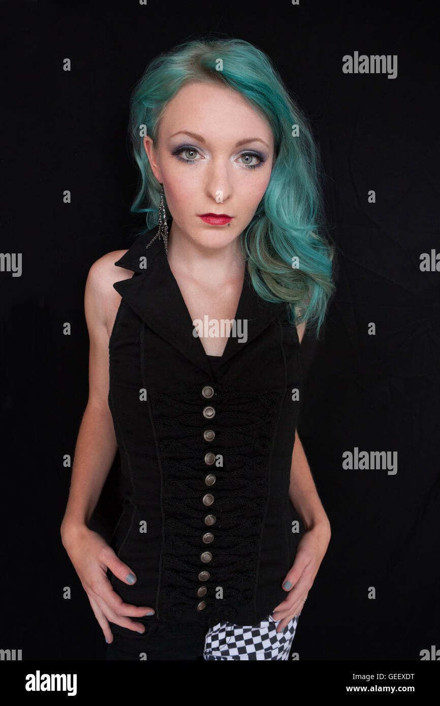 Hübsche junge Frau mit blauen Haaren vor einem schwarzen Hintergrund Stockfoto