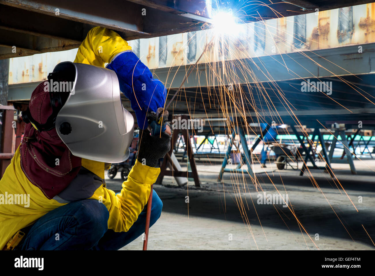 Workshop in der Fabrik Industrie Herstellung Industrie Arbeiter mit Schweißen Stahl Reparatur Container Strukturen. Stockfoto
