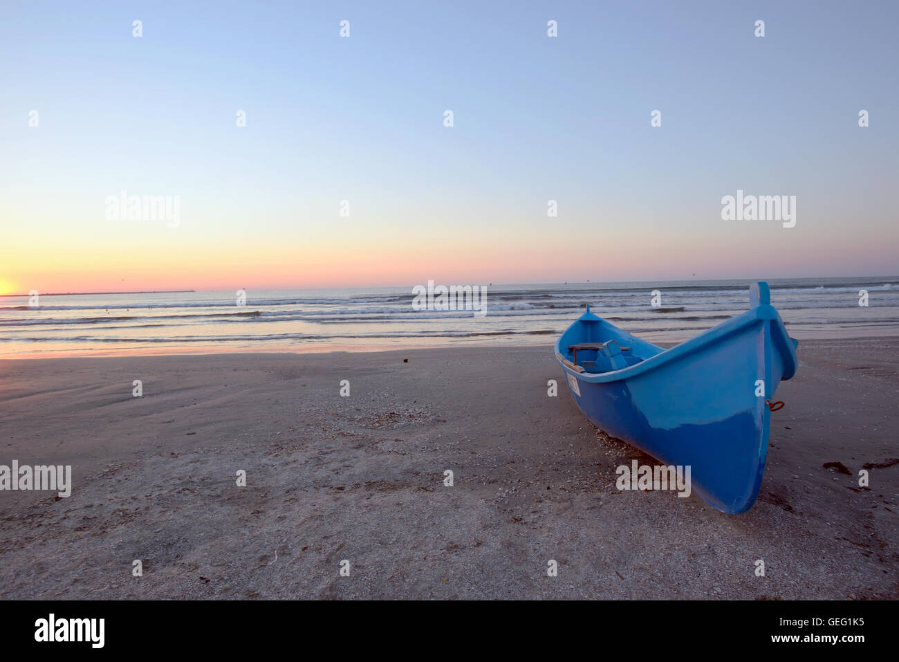 Sonnenaufgang am Strand und blau Boot Stockfoto