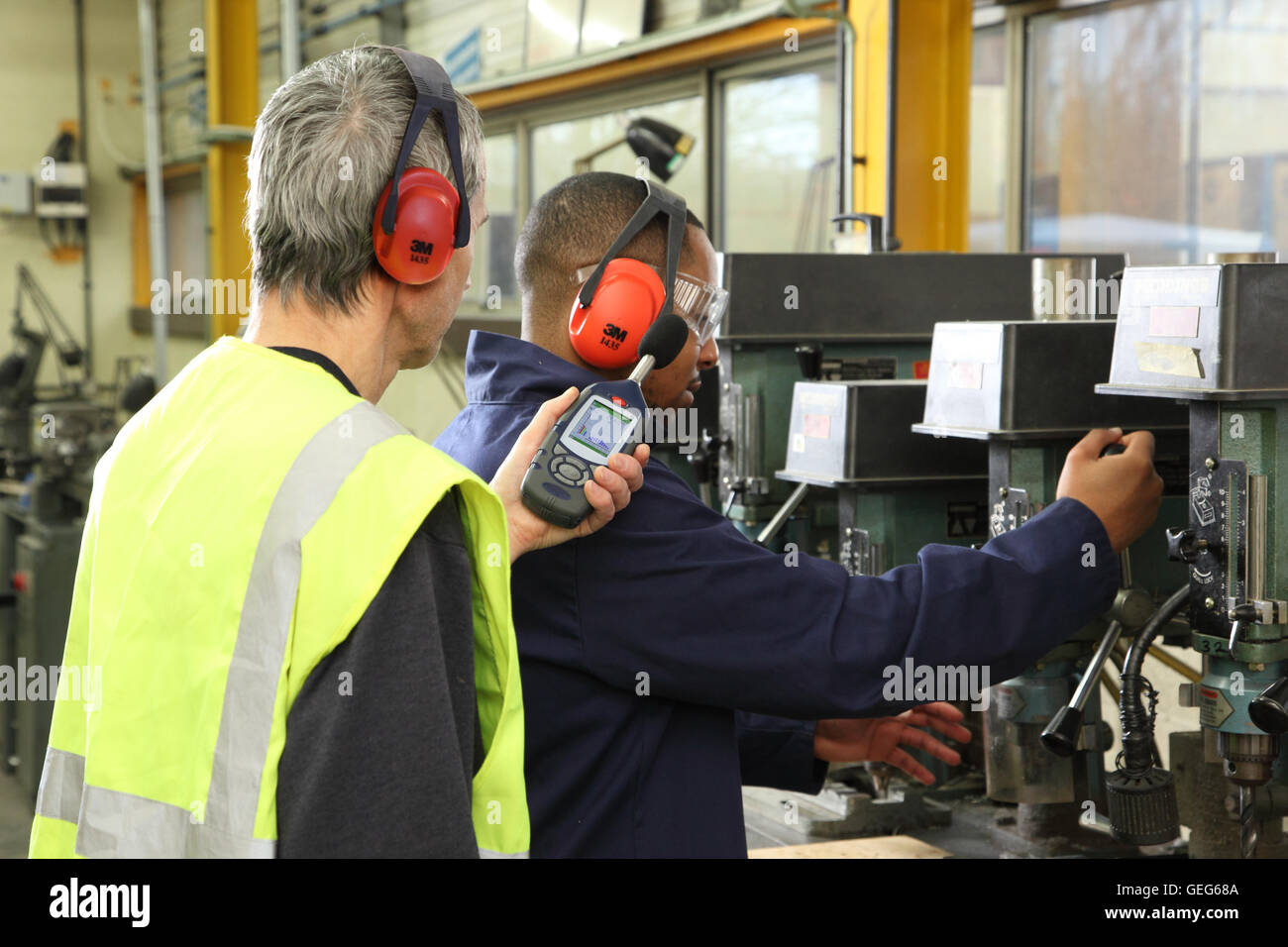 Ein Umwelt-Ingenieur überwacht Lärmpegel neben einer Bohrmaschine an eine UK Produktionsstätte Stockfoto
