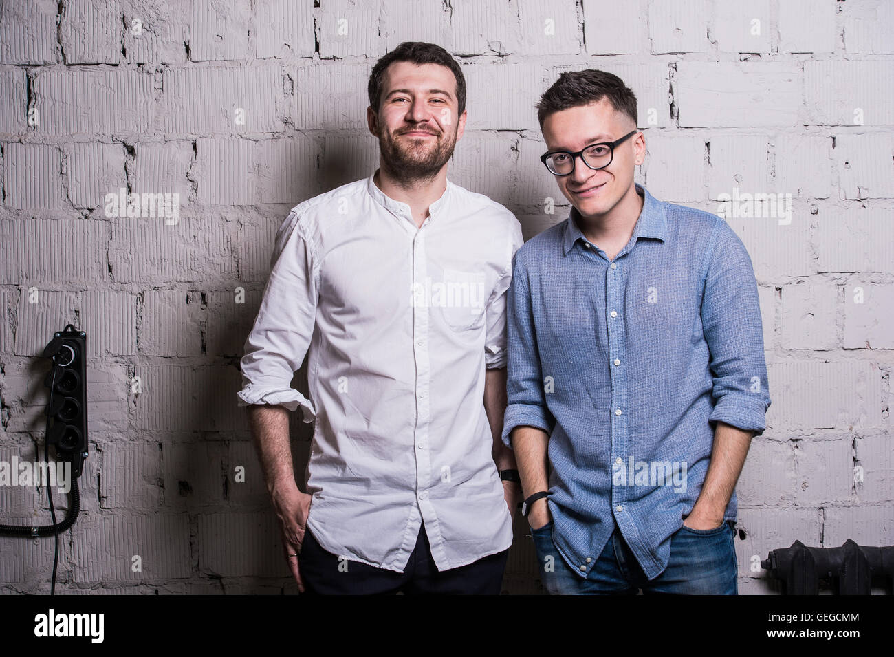 Zwei junge Männer Startupers über graue Mauer loft Innenarchitektur Stockfoto