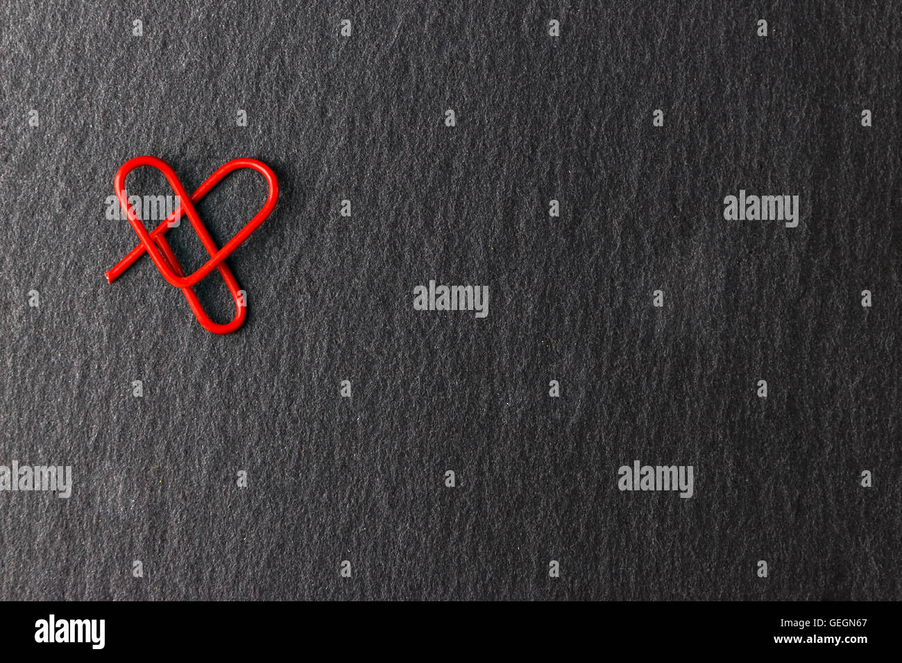 Roten Clip herzförmigen auf schwarzem Hintergrund. Liebe-Konzept für Liebhaber. Stockfoto