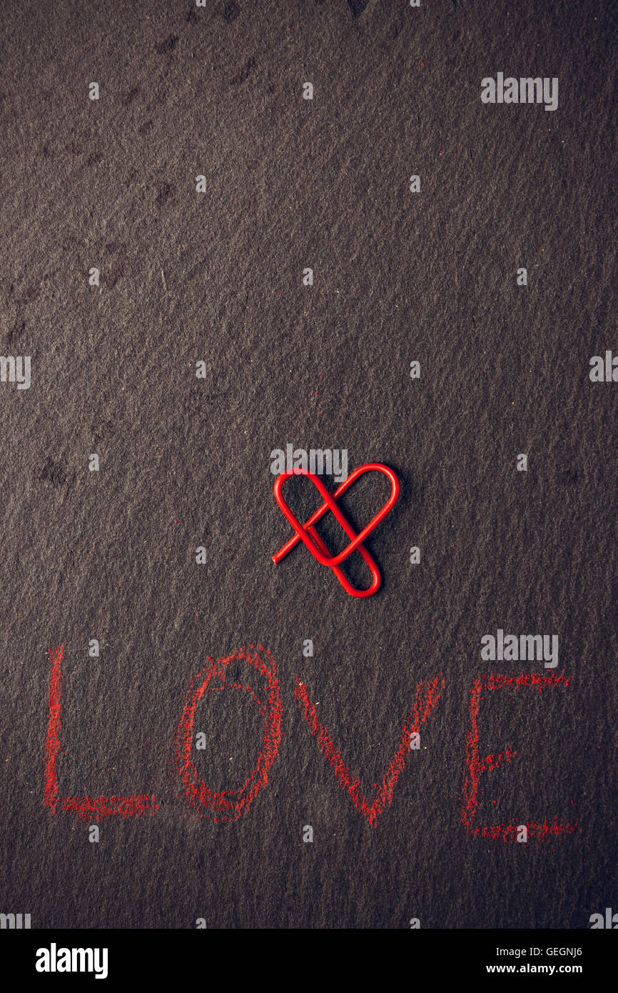 Liebe-Konzept für Liebhaber mit herzförmigen Clip gemacht. Vertikales Bild. Stockfoto