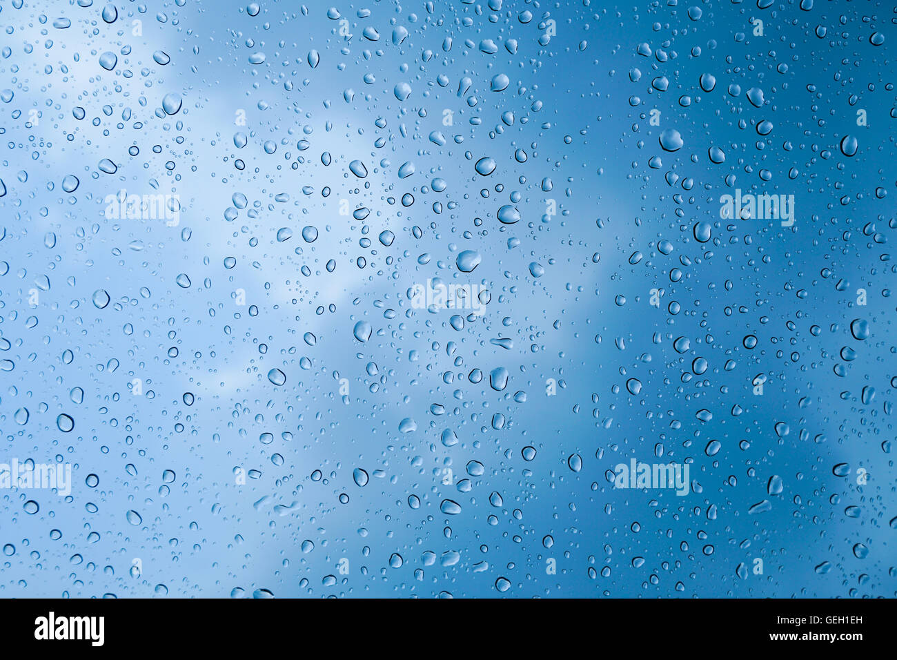 Regentropfen auf Glas mit Himmelshintergrund Stockfoto