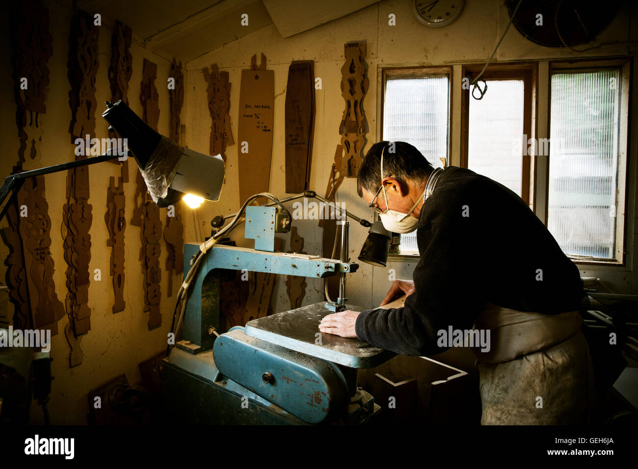 Ein Mann in einem Möbelhersteller Werkstatt, sah mit Hilfe einer Maschine. Stockfoto