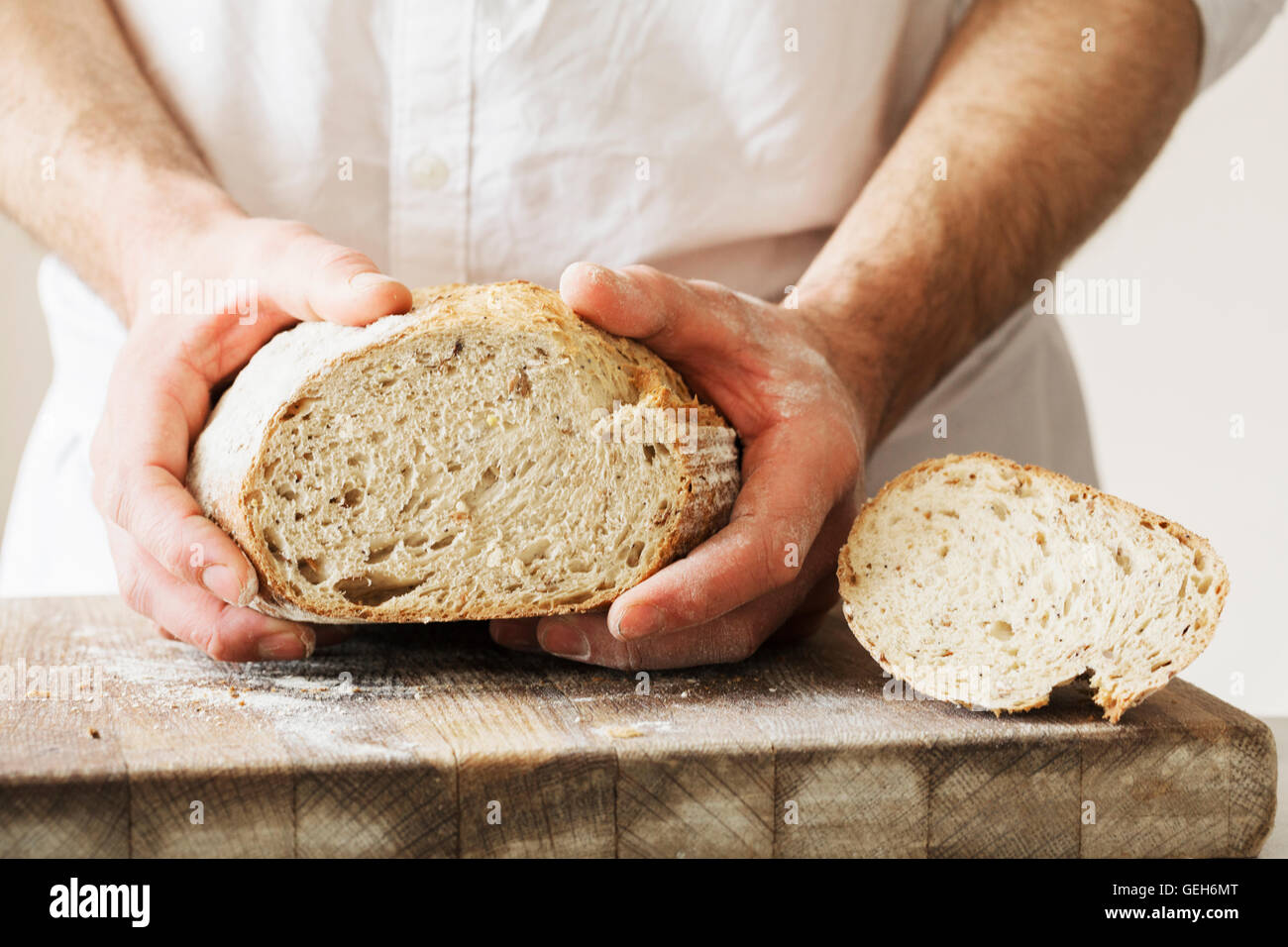 Baker, die holding ein frisch gebackenes Brot. Stockfoto