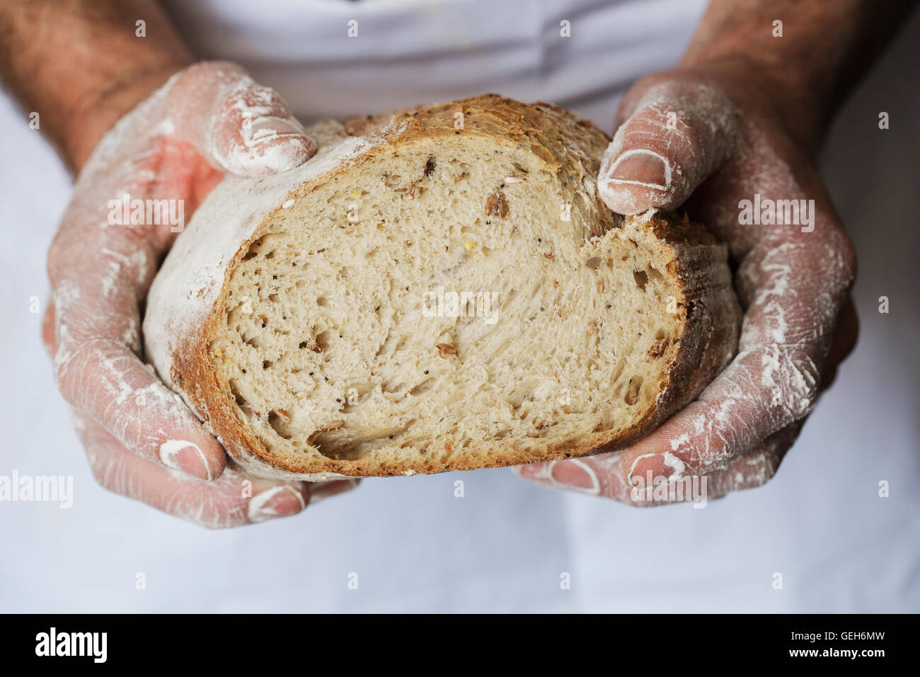 Baker, die holding ein frisch gebackenes Brot. Stockfoto