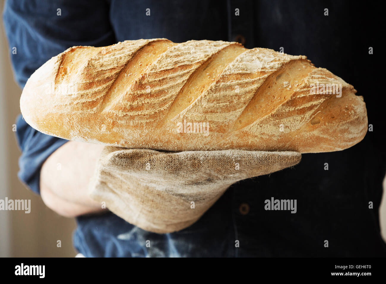 Baker, die holding zwei frisch gebackene Brote. Stockfoto