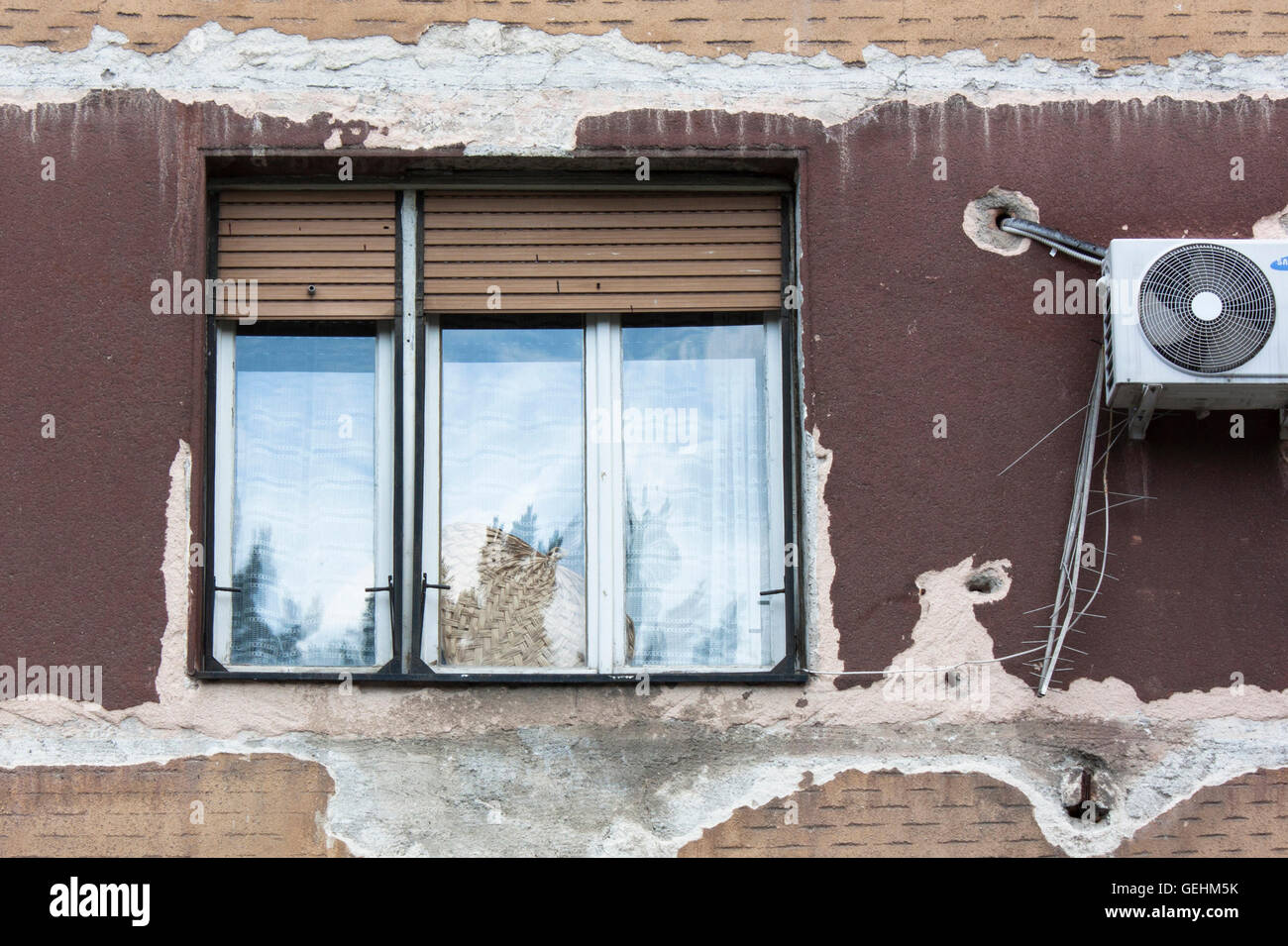 Detail von einem vernachlässigten Gebäude Fassade im Zentrum von Belgrad, mit einem Fenster und eine Klimaanlage. Stockfoto