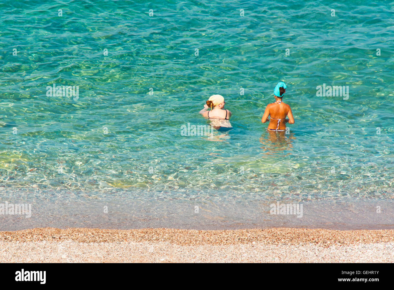 Petrovac, Montenegro - 12. Juli 2016: Zwei junge Frauen mit unterschiedlichen Hauttyp Eintauchen ins Wasser Stockfoto