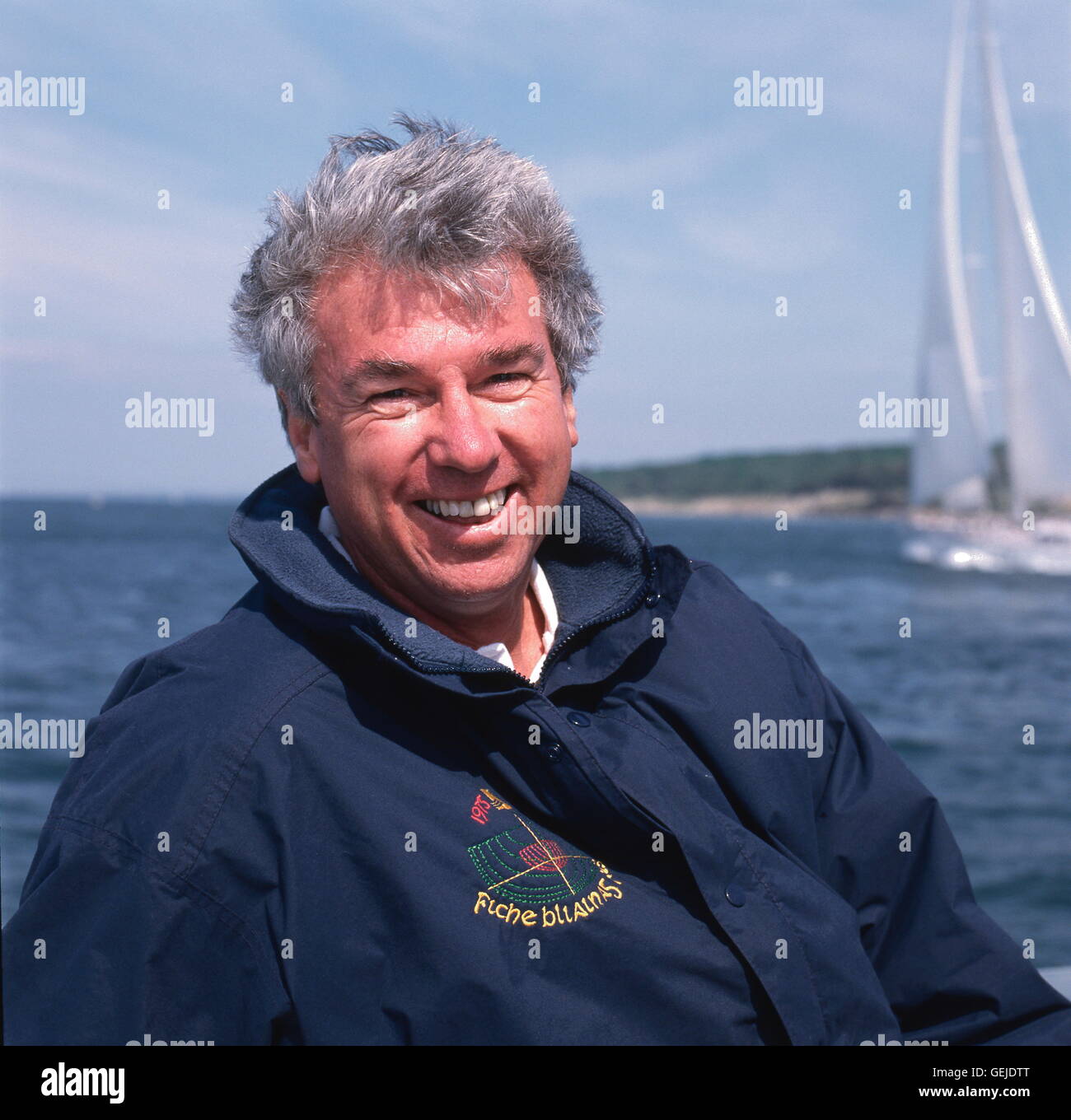 AJAXNETPHOTO. 1996. SOLENT, ENGLAND. -YACHT-DESIGNER - RON HOLLAND UHREN SEGELN STUDIEN VON SEINER SUPERYACHT DESIGN JULIA (ROYAL HUISMAN/HOLLAND) IM HINTERGRUND ZU SEHEN.  FOTO: JONATHAN EASTLAND/AJAX-REF: () PEO HOLLAND RON 930471075 Stockfoto