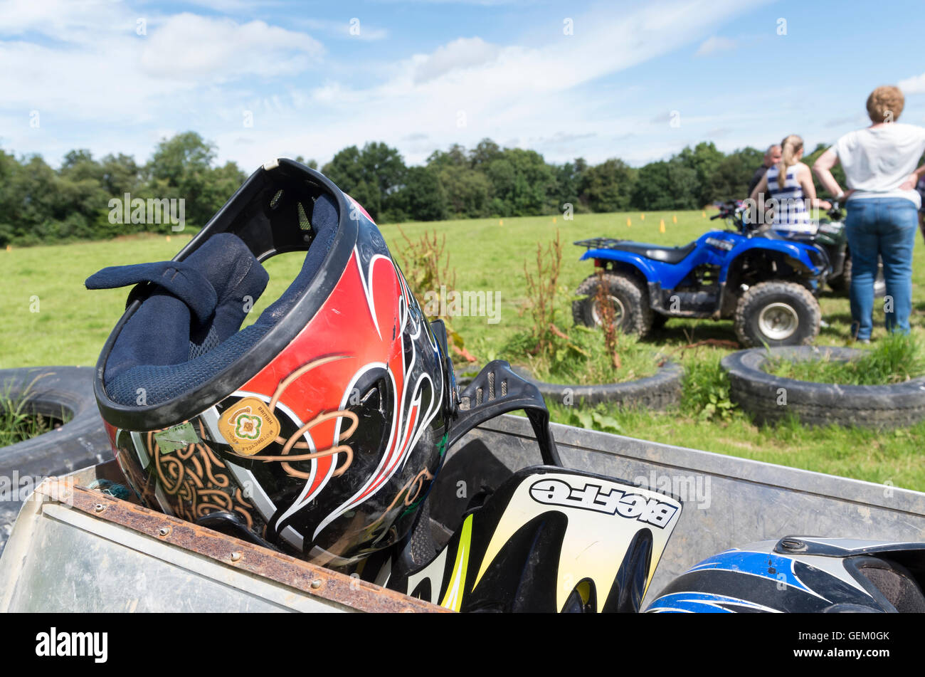 Motorrad / Motorsport Helme in einem Behälter mit Menschen und Quad Bike im Hintergrund ein Abenteuer Sport Erlebnis Stockfoto