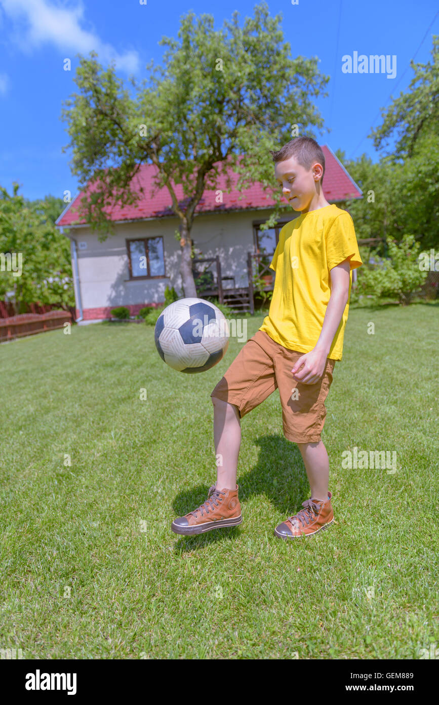 Junge mit Ball auf grünem Rasen. Sommer-Zeit! Stockfoto