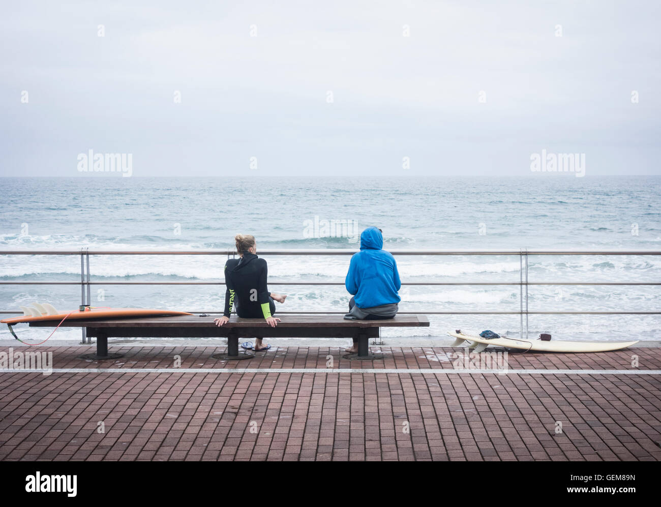 Junge weibliche Surfer mit Surfbrettern Blick auf das Meer Stockfoto