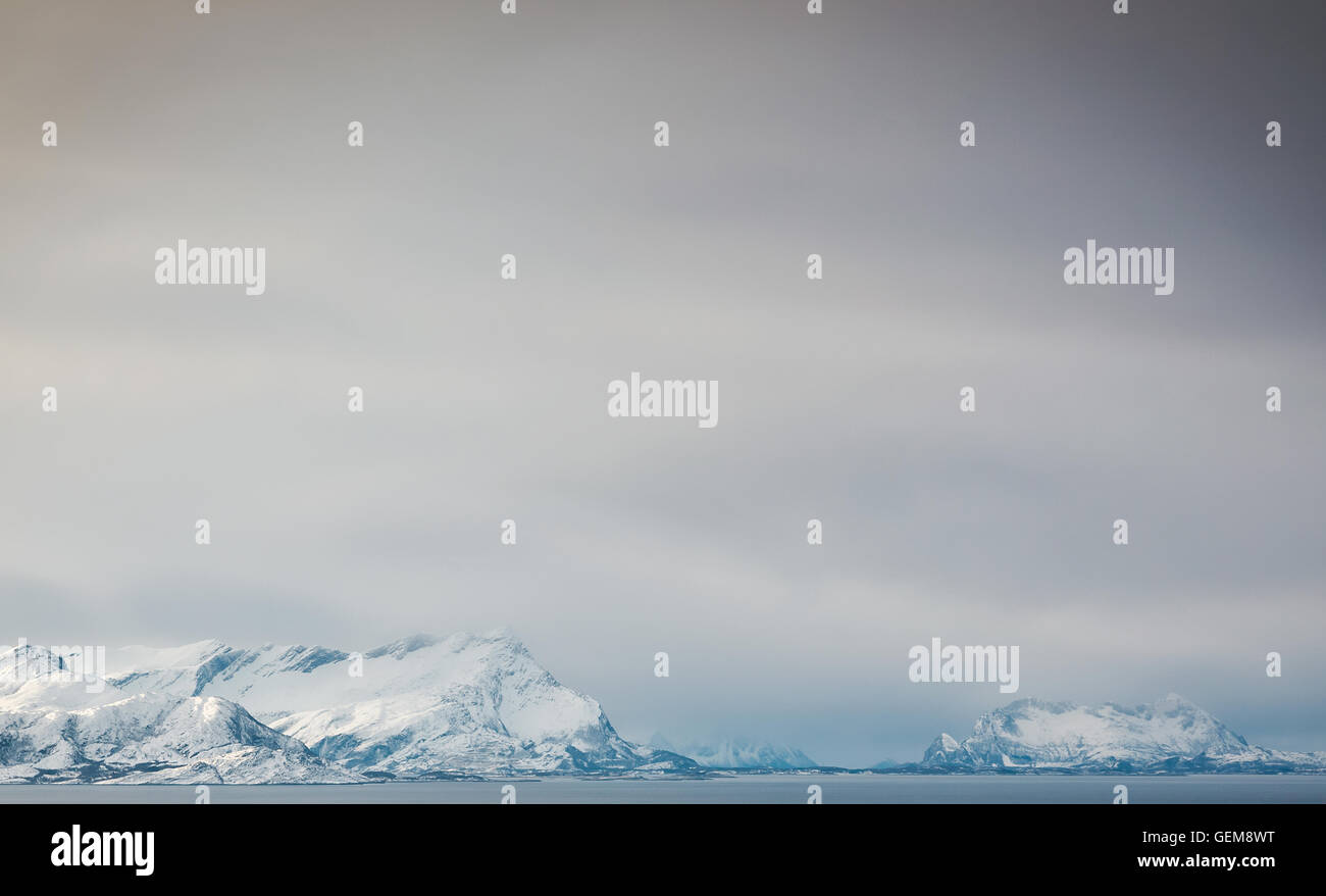 Schneebedeckte Berge steigt vom Meer im Norden Norwegens. Stockfoto