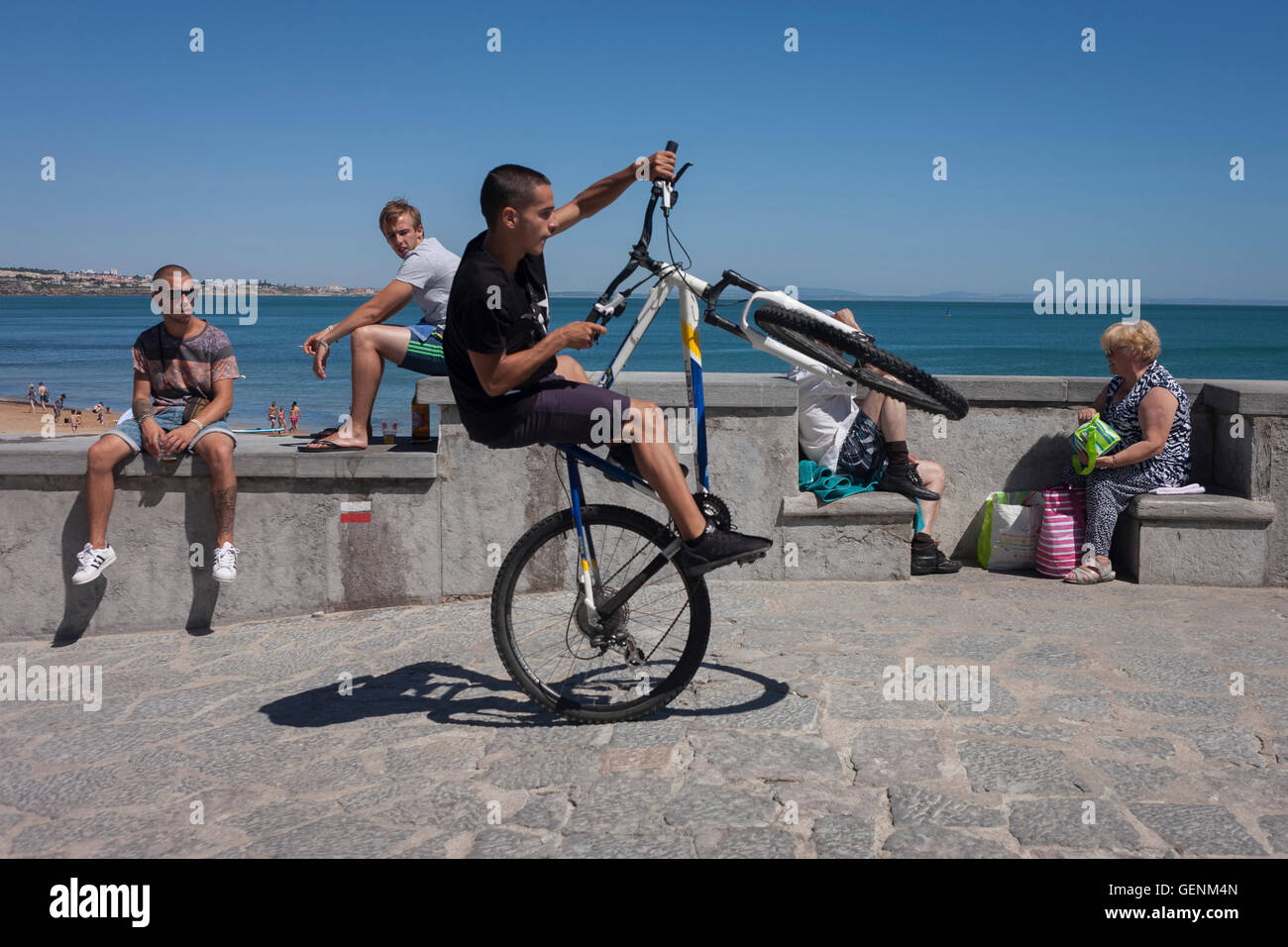 Eine Jugend in Fahrrad führt Wheelies an der Küste von Cascais, in der Nähe von Lissabon, Portugal. Stockfoto