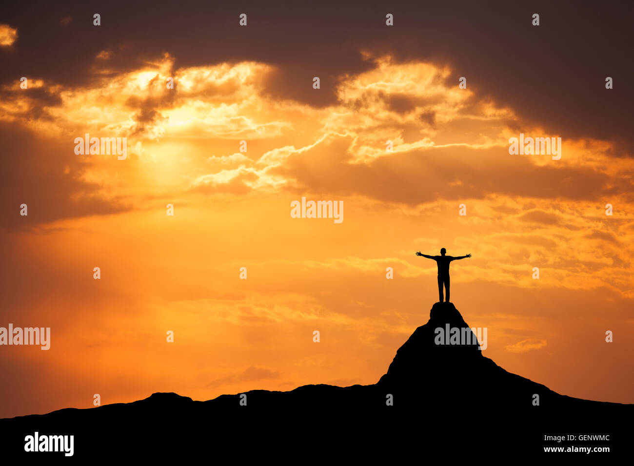 Sonnenuntergang Landschaft mit Silhouette ein stehender sportlicher Mann und wuchs bis Arme auf Berg gegen den bunten Himmel in Stockfoto