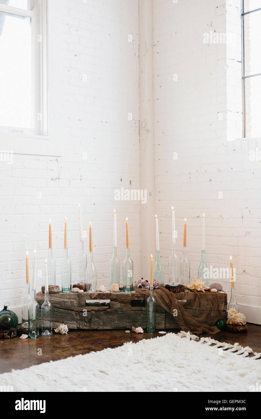 Eine Gruppe von hohen Kerzen in klarem Glasflaschen in einer Ecke angeordnet. Stockfoto