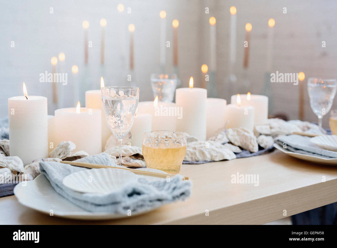 Ein Tisch mit Kerzen, China Teller und Gläser. Stockfoto