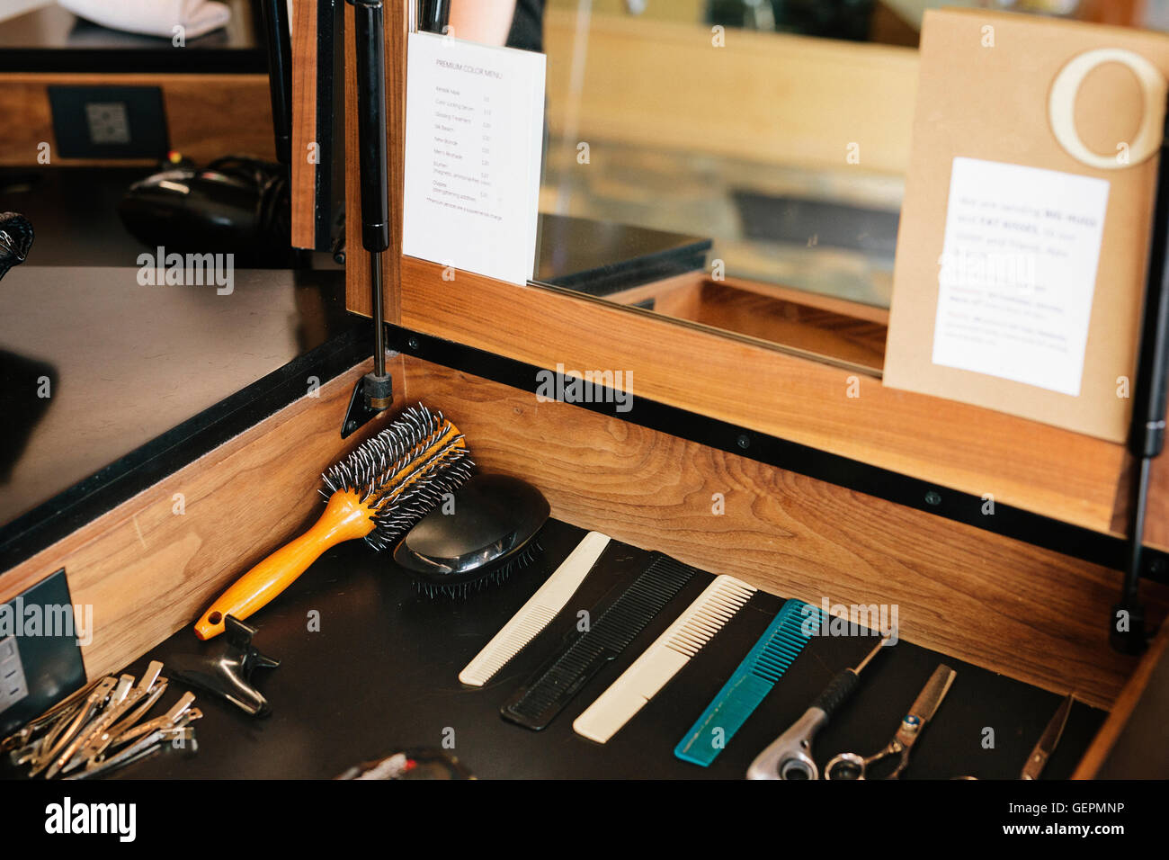 Eine Workstation mit Scheren, Kämme und Haarnadeln legte ordentlich vor einem Spiegel. Stockfoto