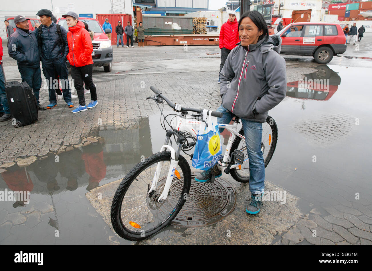 Mann auf einem Fahrrad an der Fähre Hafen, Aasiaat, Grönland Stockfoto