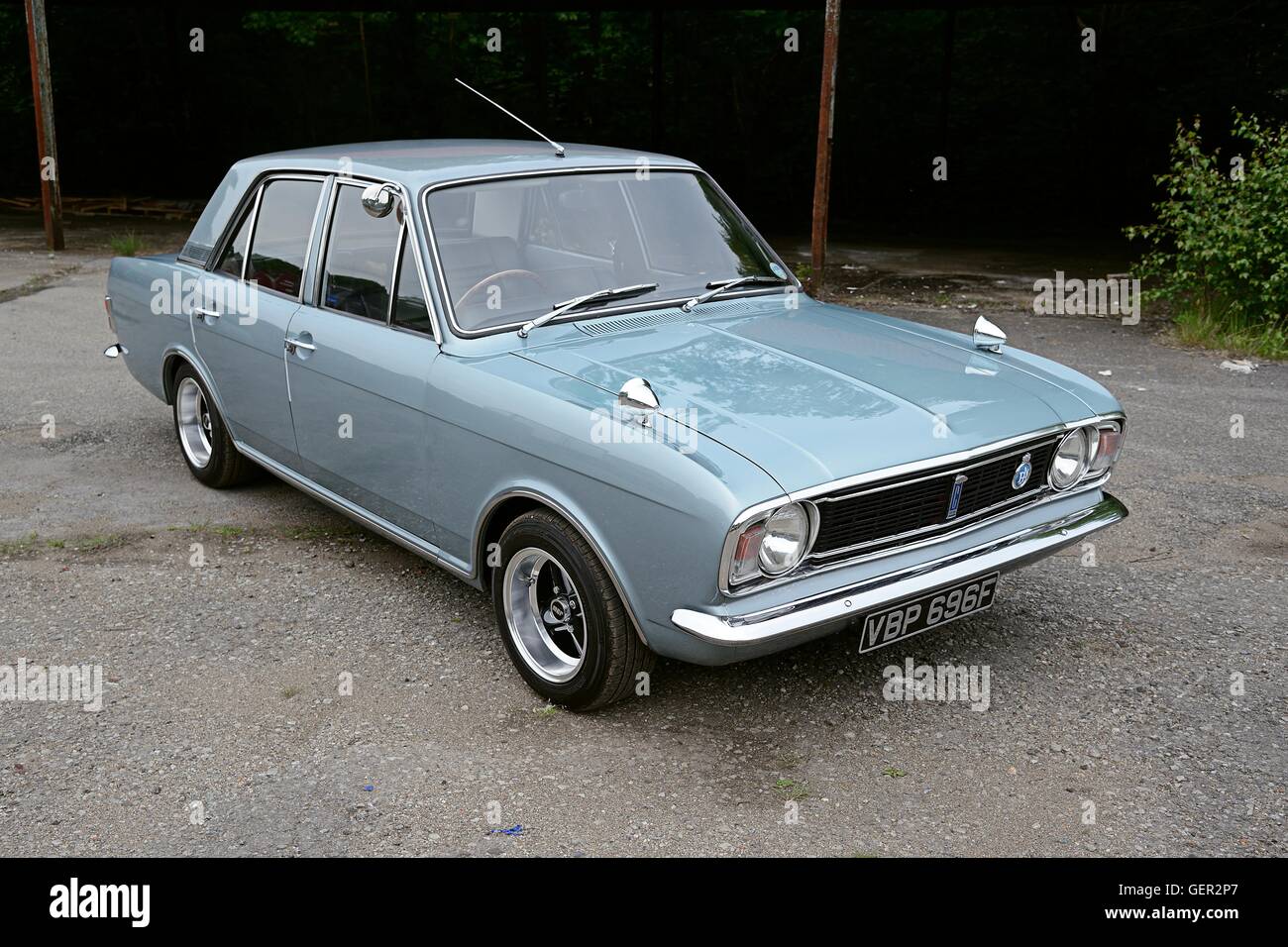 Ein 60er Jahre Ford Cortina MkII Saloon steht auf Beton vor einem alten überdachten Schuppen Stockfoto