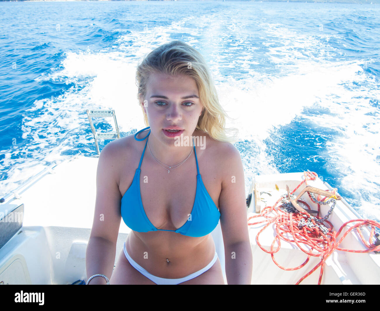 Eine schöne Blondine fährt ein Motorboot in ihrem bikini Stockfoto