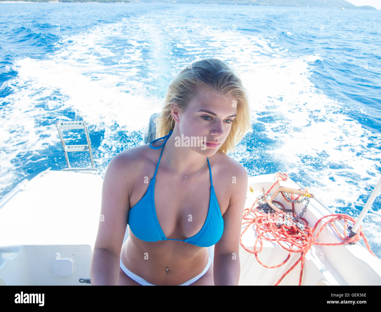 Eine schöne Blondine fährt ein Motorboot in ihrem bikini Stockfoto