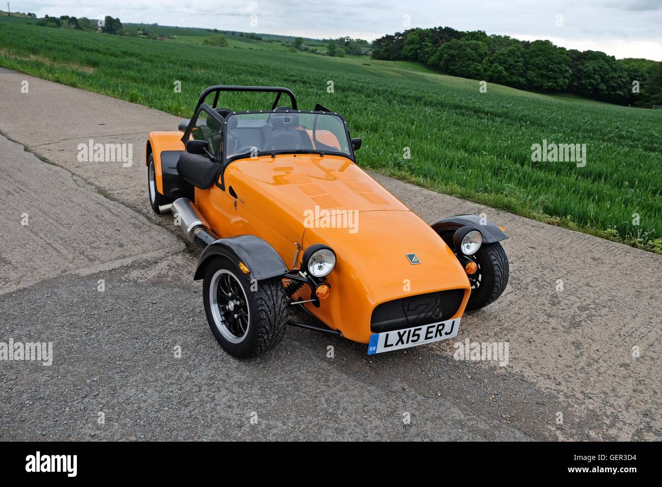 Ein oranger Caterham-Sportwagen auf der alten Landebahn Stockfoto