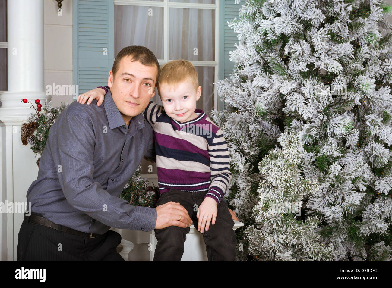 Fürsorglicher Vater mit seinem Sohn posieren für ein gemeinsames Porträt. 19. Juni - einen internationalen Feiertag Vatertag. Familien Fotoshooting Stockfoto