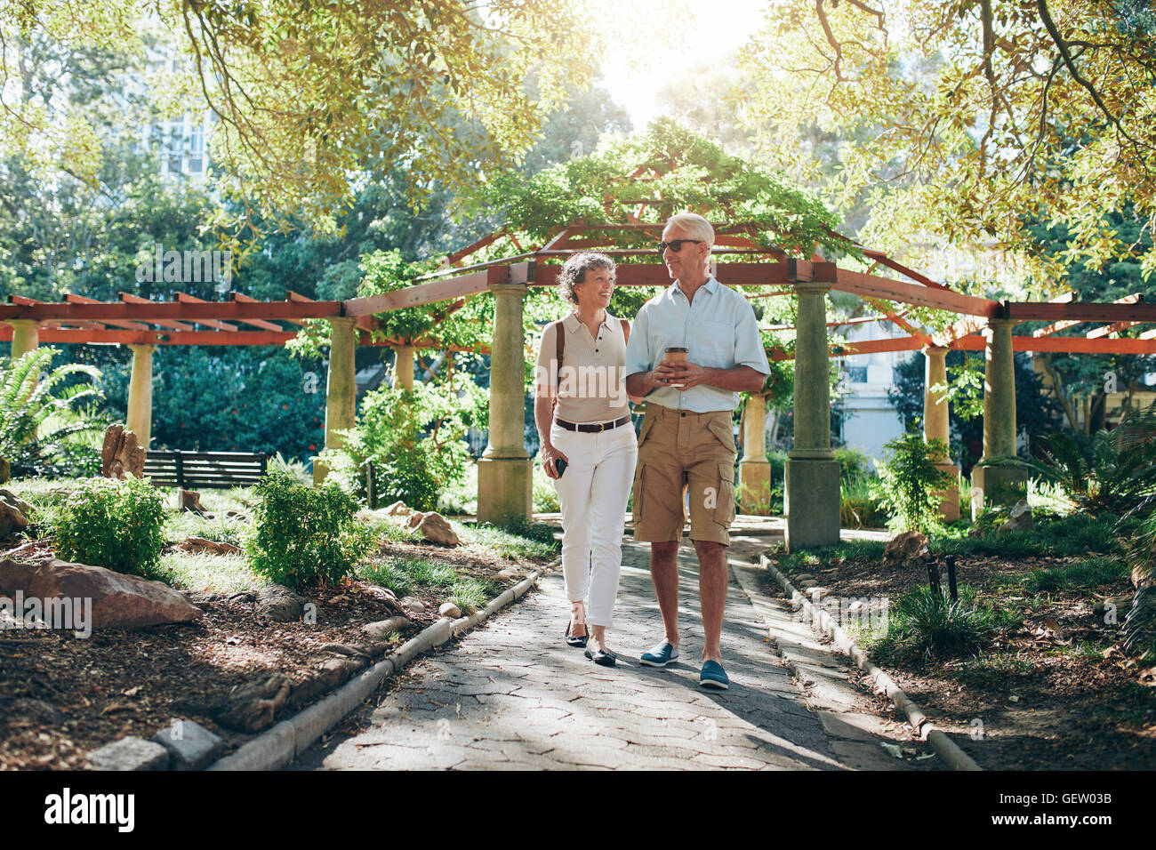 In voller Länge Portrait von senior Brautpaar zusammen in einem Stadtpark spazieren. Reifer Mann und Frau in den Urlaub. Stockfoto