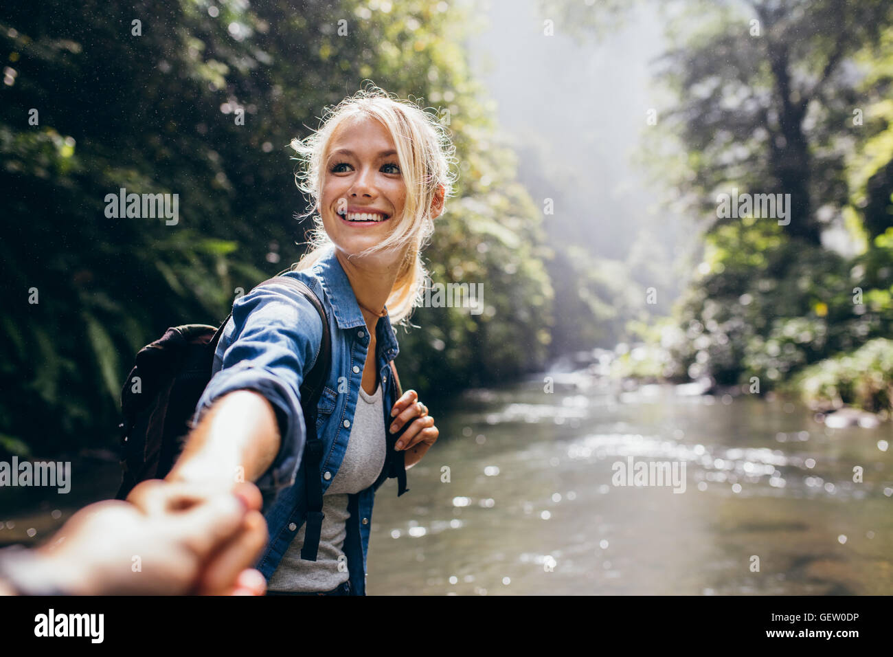 Wanderer-Frau hält die Hand des Menschen und führt ihn auf die Natur im Freien. Paar in der Liebe. Point Of View erschossen. Stockfoto
