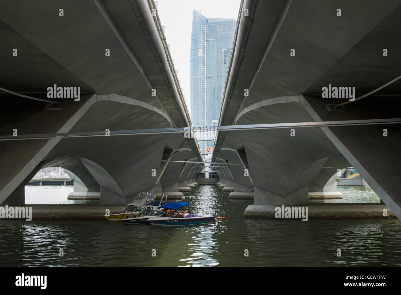 Drei Boote gefesselt unter zwei Brücken in Marina Bay. Stockfoto