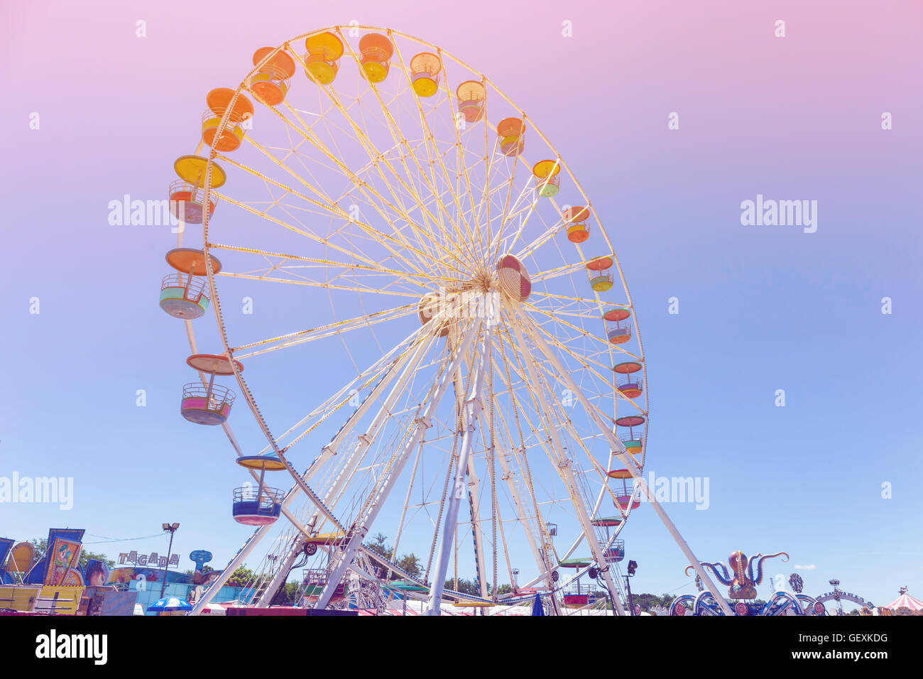 Riesenrad im Vergnügungspark mit blauem Himmel Hintergrund Pastell Farbton Stockfoto