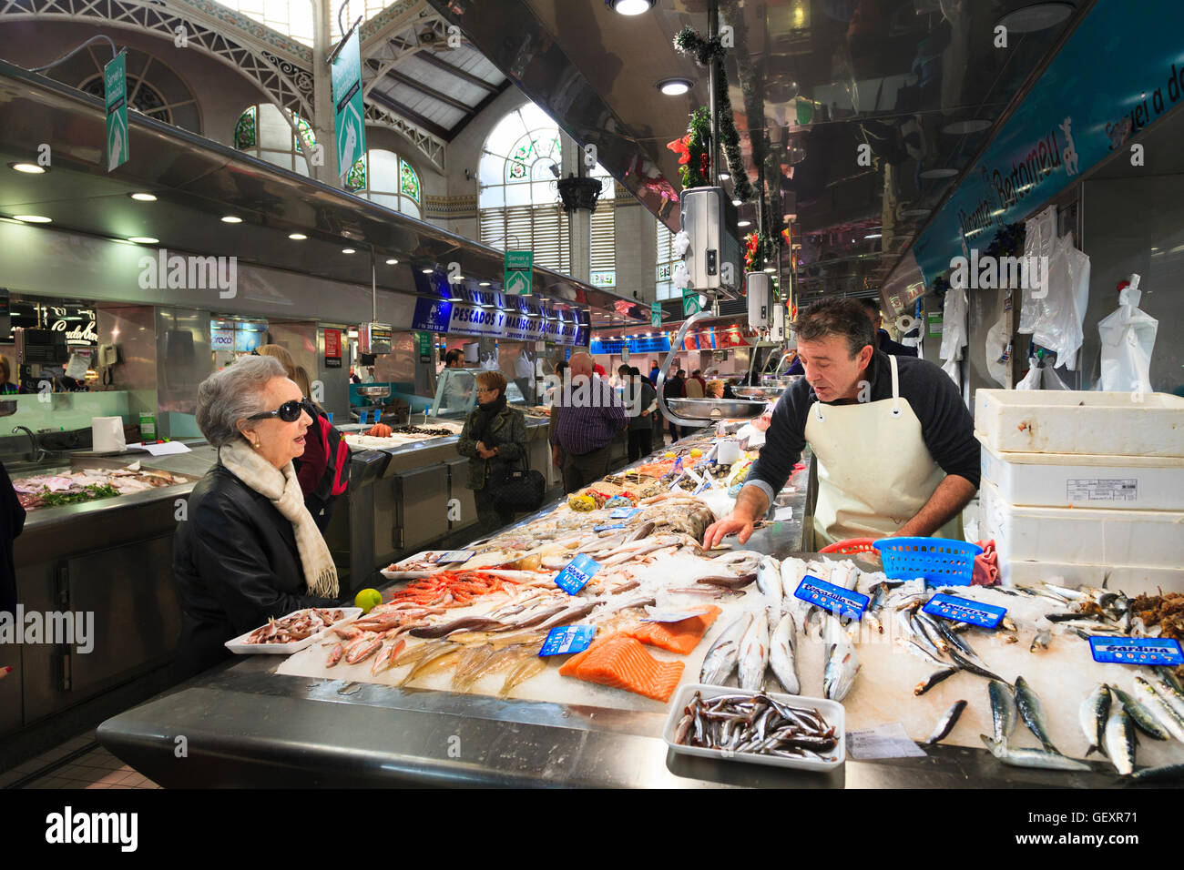 Markt-Händler Auswahl Fisch für einen Kunden in der Zentralmarkt von Valencia. Stockfoto