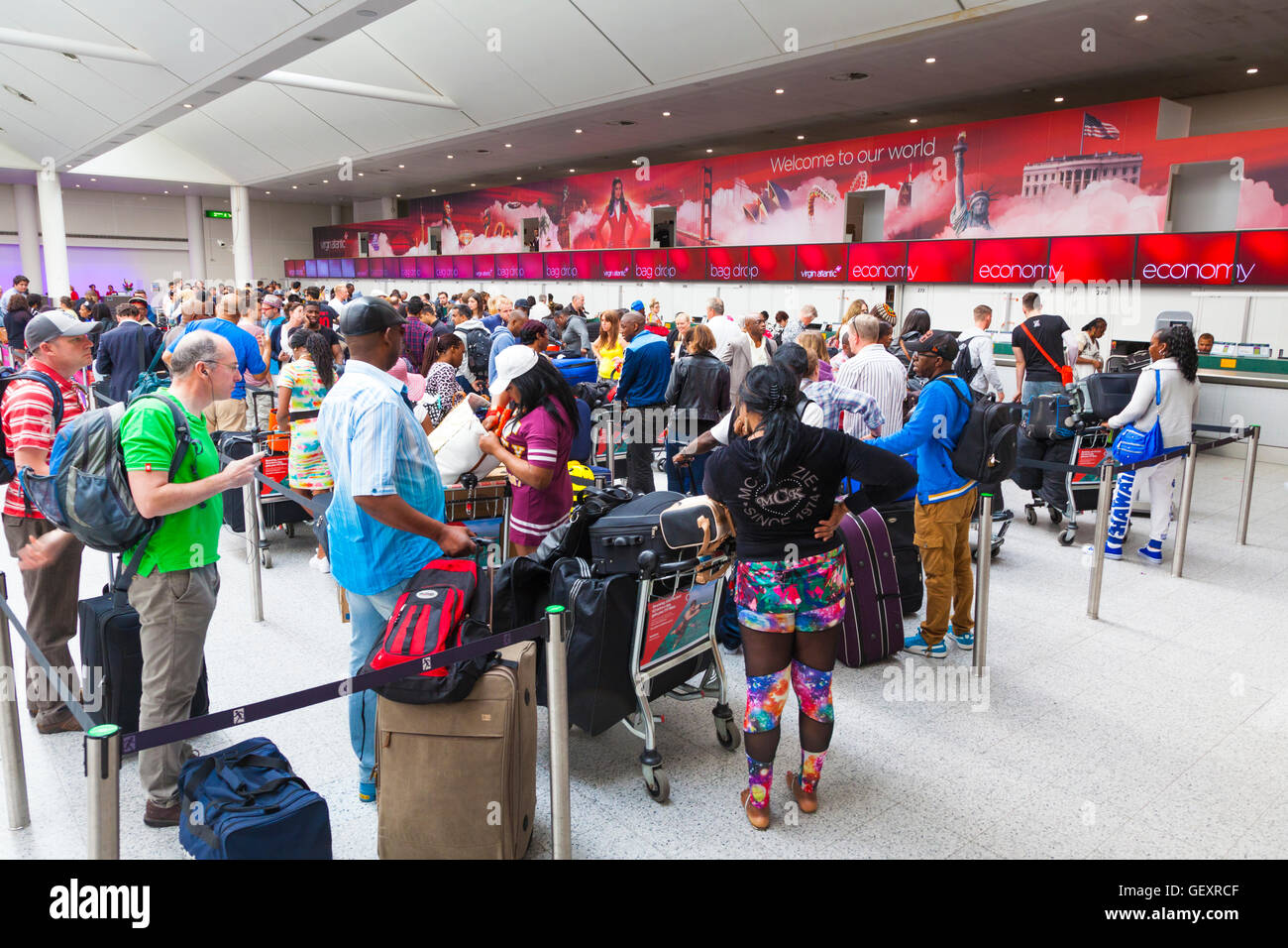 Lange Schlange der Passagiere, die darauf warten, an Virgin Atlantic Schaltern einchecken. Stockfoto