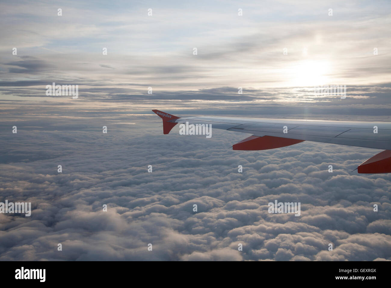 EasyJet Flugzeugflügel über Decke Wolke mit der aufgehenden Sonne. Stockfoto