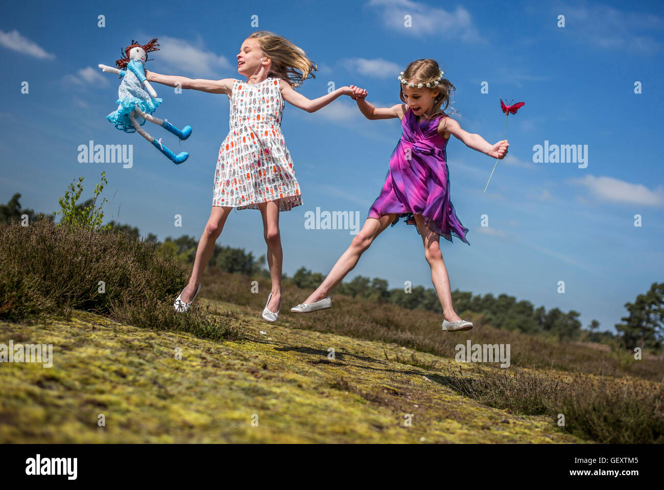 Eineiige Zwillinge spielen zusammen unter freiem Himmel. Stockfoto