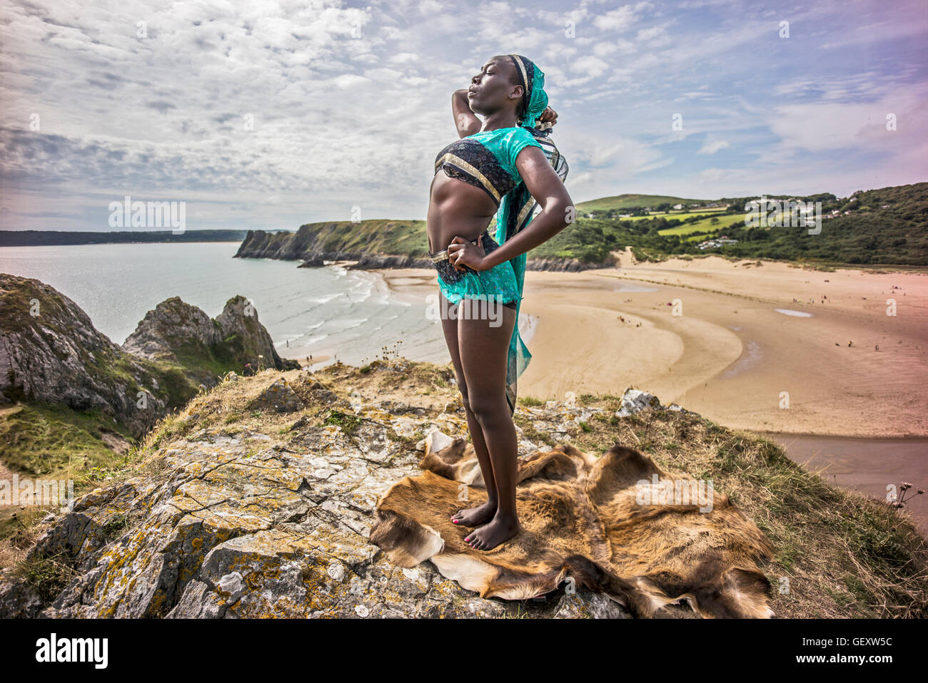 Eine Afro karibische Frau entspannend auf Hügeln mit Blick auf drei Clffs Bucht auf der Gower. Stockfoto