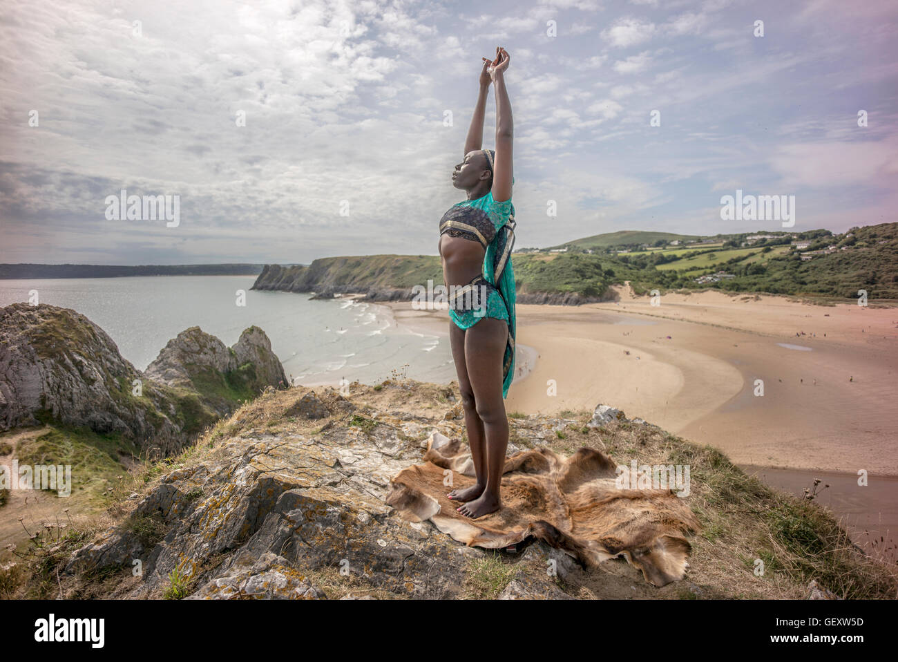 Eine Afro karibische Frau entspannend auf Hügeln mit Blick auf drei Clffs Bucht auf der Gower. Stockfoto