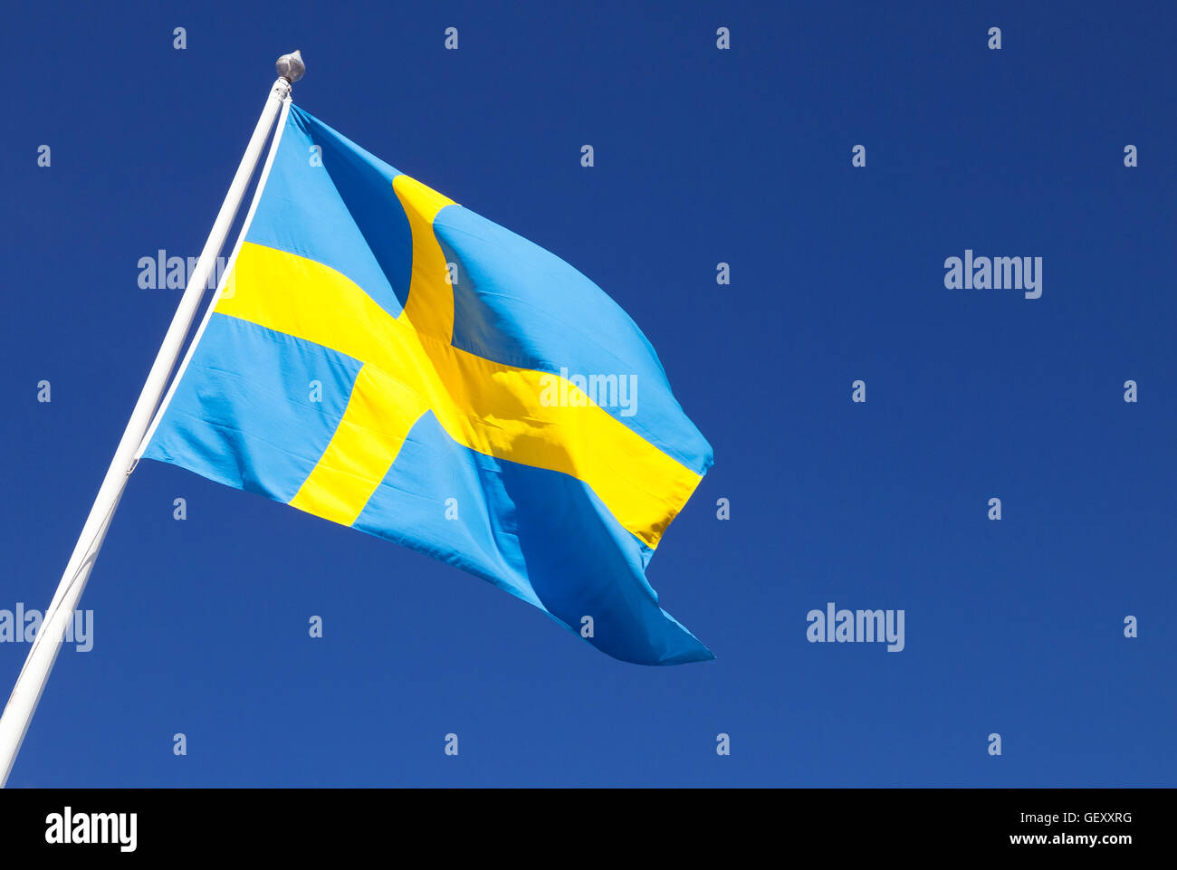 Wehende Wind schwedische Flagge über tiefblauen Himmelshintergrund Stockfoto