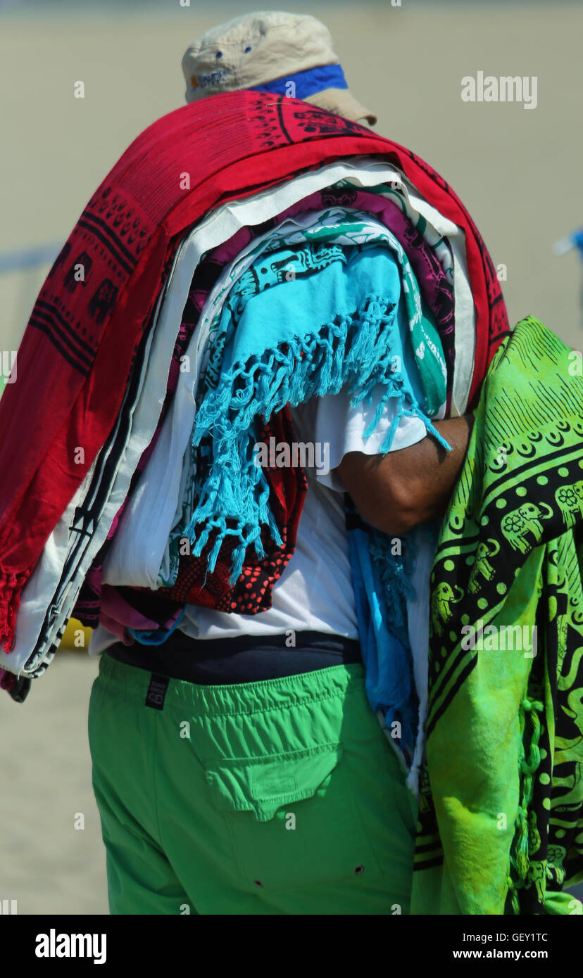 Afrikanische Hausierer der Bettwäsche und Handtücher am Strand im Sommer Stockfoto